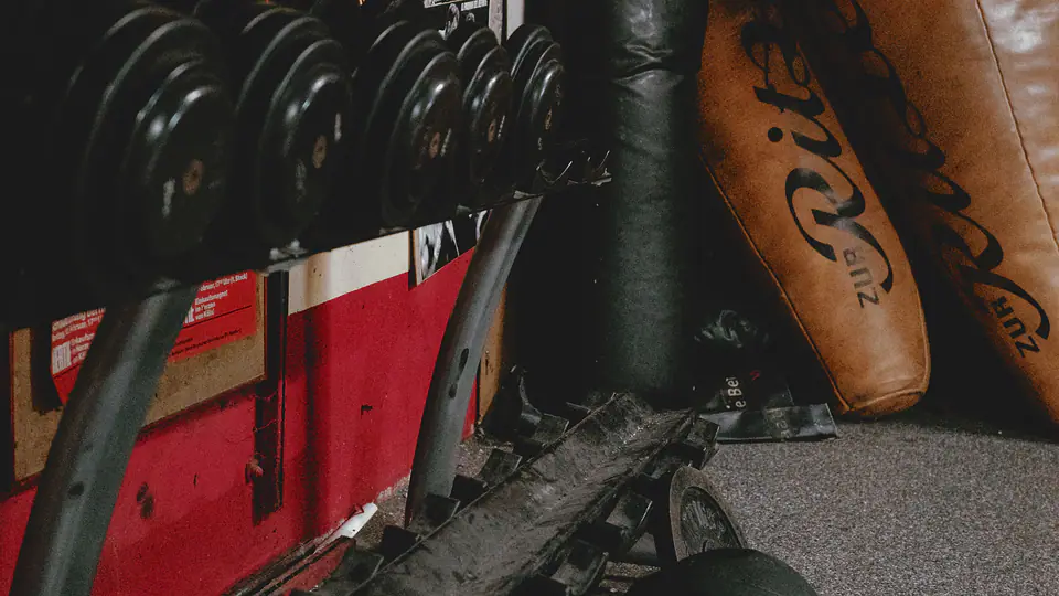 Old-school boxing gym with fight posters, heavy bags and a dumbbell rack