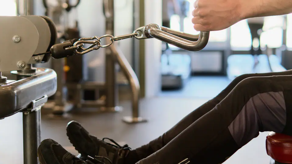 Person pulling the handle of a seated cable row machine