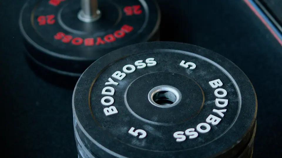 Stack of rubber bumper plates on a gym floor