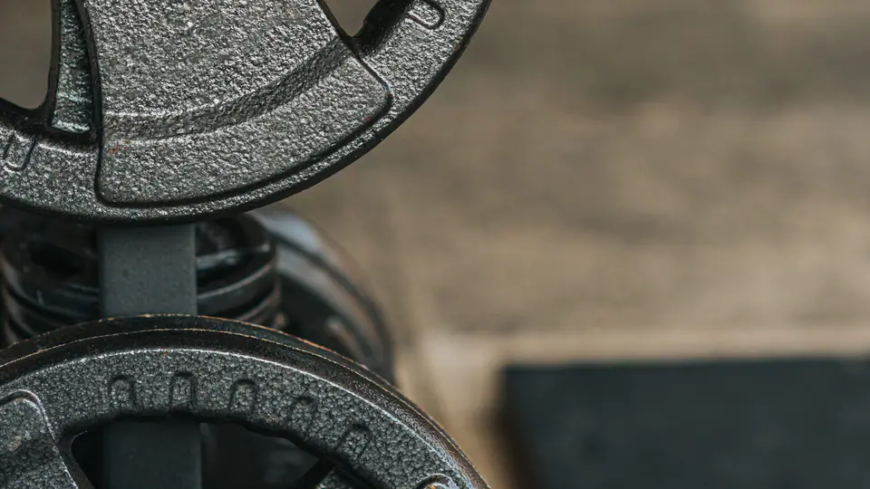 Stack of 20 kg cast-iron weight plates against a brick wall