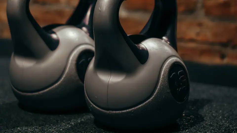 Pair of kettlebells on a gym floor in warm light