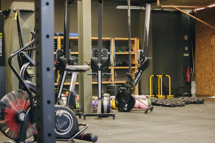 Conditioning gym with an air bike, a rower, a rig and kettlebells