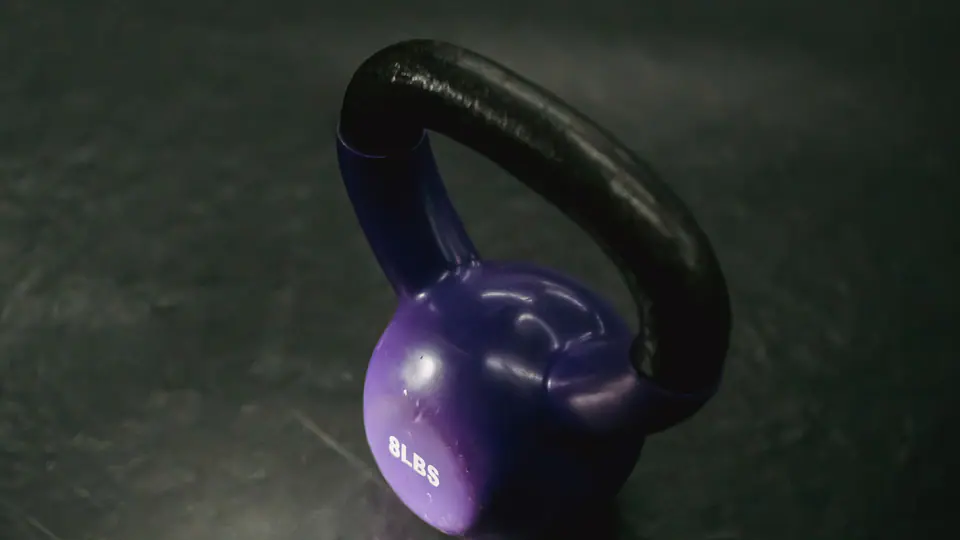 Purple kettlebell on a dark floor