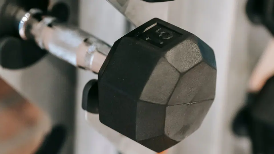 Hexagonal dumbbells stored on a white vertical rack