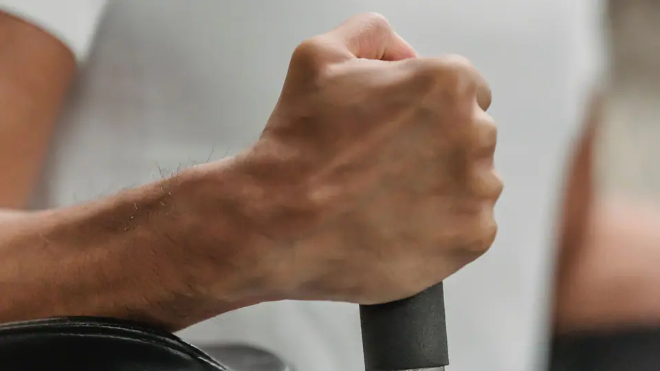 Lifter gripping a machine handle, with a towel laid over the seat