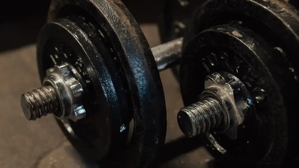 Pair of spin-lock dumbbells on the floor at the foot of a bed