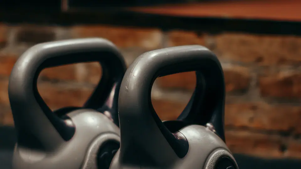 Pair of kettlebells on a gym floor in warm light